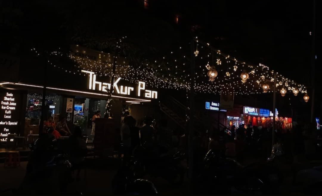 Thakur Pan storefront lit up at night in Akota